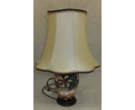 A Moorcroft Pottery table lamp decorated with honeysuckle, roses and violets on a graduated green and peach ground, together 