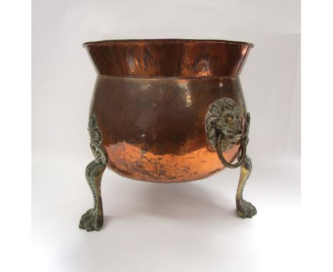 A 19th Century copper coal bin with lion mask ring handles raised on paw feet 
