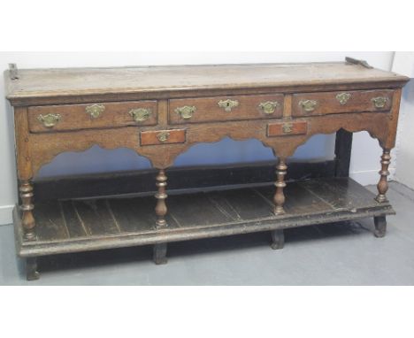 18TH CENTURY WELSH OAK DRESSER BASE with later associated open two shelf rack, the base with moulded edge over three moulded 