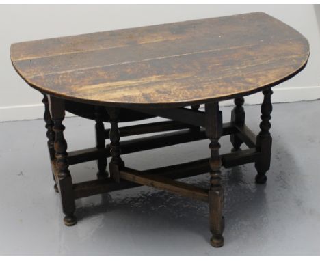 LATE 17TH CENTURY STAINED OAK GATE LEGGED TABLE on baluster turned legs and standing on bun feet, having single drawer, on st