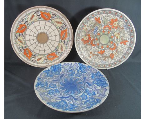 THREE LARGE CROWN DUCAL POTTERY CHARGERS BY CHARLOTTE RHEAD, having tube lined floral and foliate stylised decoration, variou