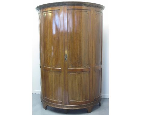 EARLY 20TH CENTURY GEORGIAN STYLE MAHOGANY BOW FRONT DOUBLE WARDROBE, having moulded dentil cornice over two blind panelled d