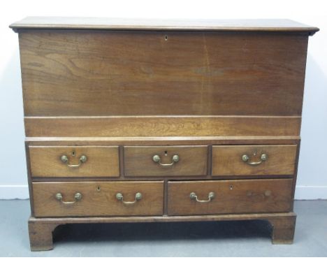 EARLY 19TH CENTURY WELSH OAK ONE PIECE MULE CHEST, having hinged, moulded top over plain front, the projecting lower section 