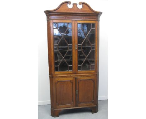 EARLY 19TH CENTURY WELSH OAK TWO STAGE CORNER CABINET, having broken swan neck pediment over a pair of reeded, astragal glaze