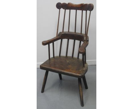 PRIMITIVE WELSH COMB BACKED FIRESIDE ARMCHAIR with shaped cresting over scrolled arms on a solid slab seat with turned legs. 