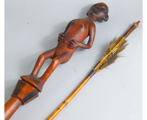 A Tribal figural spear staff, with shaped hourglass end, and nude pommel and an arrow 116cm wide.