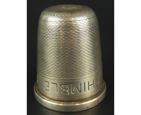 A George V silver toasting or stirrup cup, engraved 'Just a thimble full', modelled in the form of a thimble, with engine tur