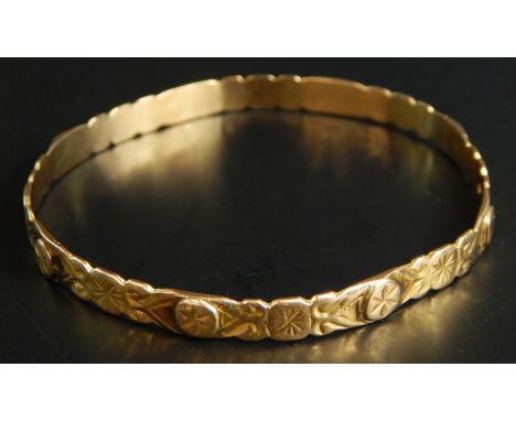 A bangle, of floral engraved design, with star design, yellow metal, unmarked, 14.2g all in. 