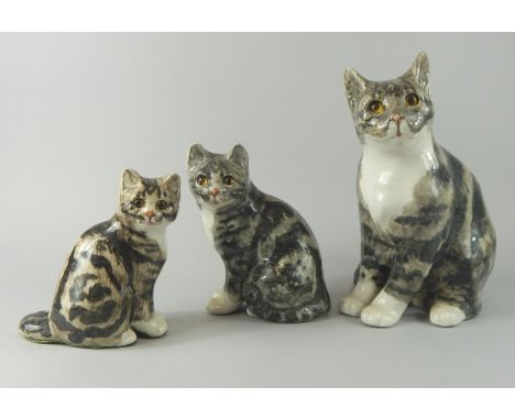 A graduated set of three Winstanley ceramic cats, each with glass eyes, the largest 29.5cm high