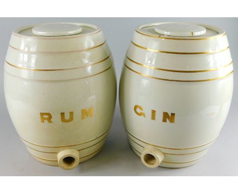 Two early 20thC pottery spirit jars, for Rum, 33cm high, and another for Gin, with open fronts, and gilt stencil lettering. (