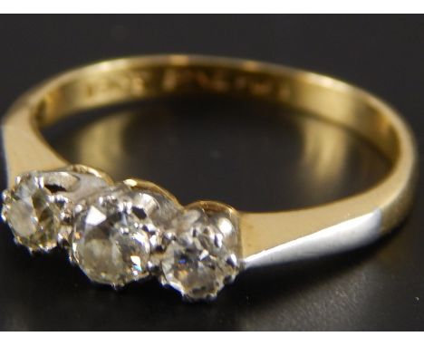 A three stone diamond ring, set in yellow metal, stamped 18ct