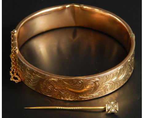 A 9ct gold bangle and a stick pin, the bangle with floral decoration, and inscription N.Storr TNJP 54/2, 15.1g, and a cross s