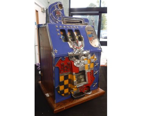 A 1930's American Mills Novelty Company fruit or slot machine, the front of the castle case cast with a heraldic type shield 