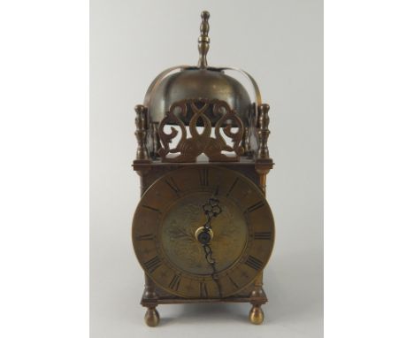A brass lantern type clock, the circular dial with blackened Roman numerals, now fitted with a later quartz movement