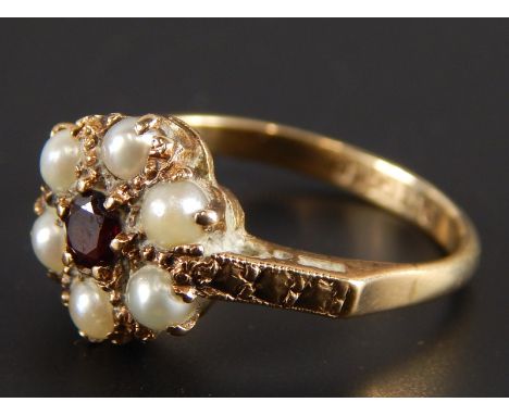 A cluster ring, set with a garnet and seed pearls, in yellow metal mount, stamped 9ct gold
