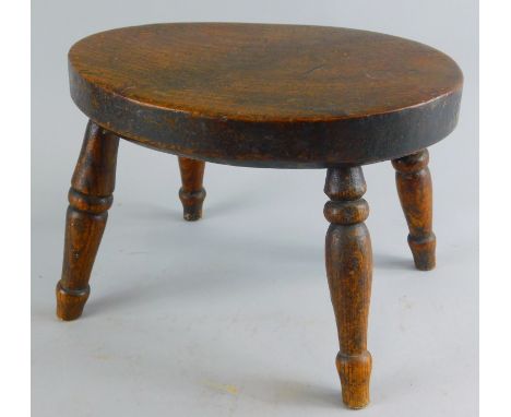 A late 19thC ash and elm stool, the oval top raised on ring turned supports, 18cm high, 28cm wide, 22cm deep. (AF). 