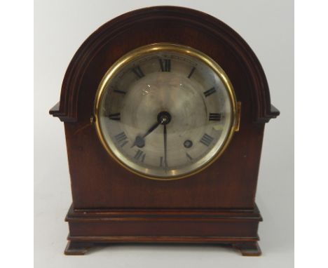 An early 20thC mahogany mantel clock, the silvered dial with Roman numerals, the arched case with ogee bracket feet, 28cm hig