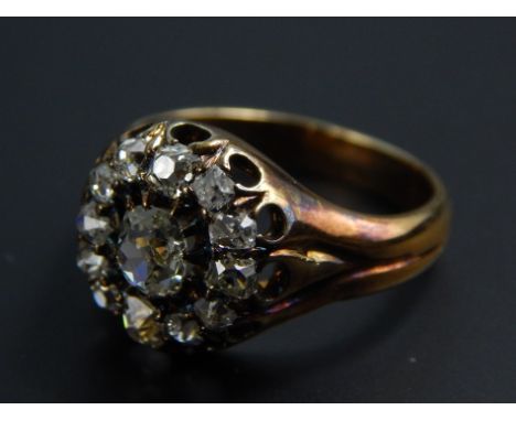 A diamond dress ring, with old mine cut stones, with larger central stone approx 0.1cts, surrounded by twelve smaller stones,