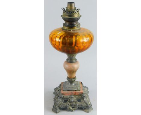 A late 19thC/early 20thC oil lamp, with metal top, inverted ceramic stem and pierced base, with amber coloured reservoir, 44c