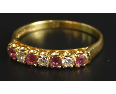 An 18ct gold ruby and diamond dress ring, set with four rubies and three diamonds, 3.1g all in. 