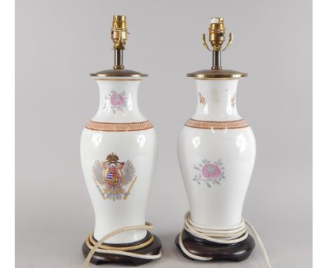 A pair of oriental style lamp bases, each decorated with an armorial of flowers, etc, sold with shades, converted from vases,