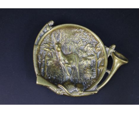 A continental brass ashtray / trinket dish, the outer in the form of a curved hunting horn with rifle, powder flask etc and t