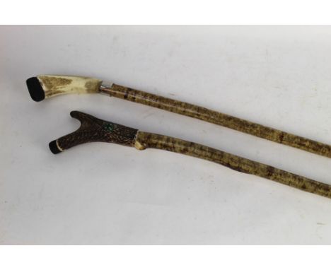 Two hazel shafted walking sticks, first with antler handle, overall height 114 cm and another with antler handle and inset co