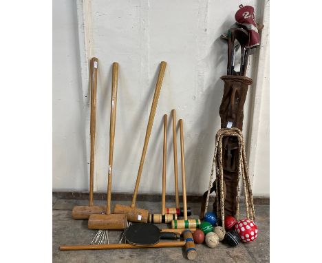 A collection of vintage golf clubs and a croquet set 