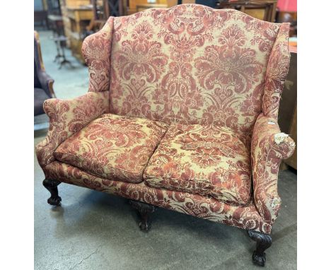 An early 20th century Chippendale Revival carved mahogany and fabric upholstered sofa 