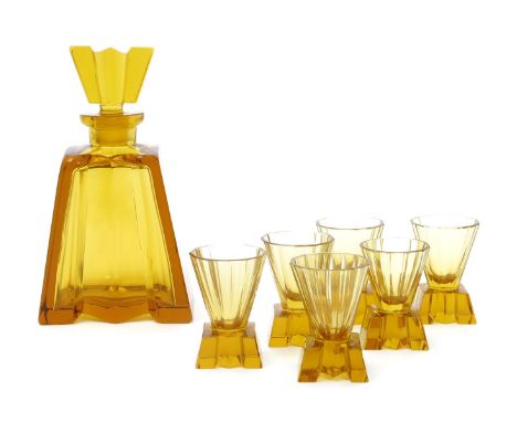 An amber glass liqueur decanter and six glasses,  tapering, faceted section with flaring triangular faceted stopper, six shot