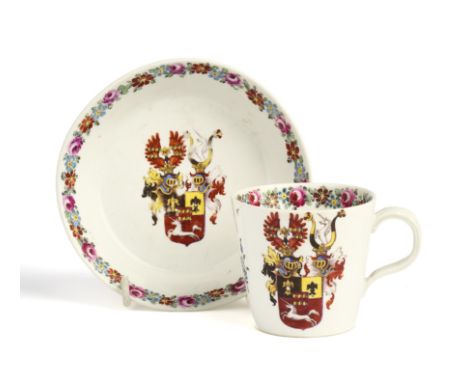 A NYMPENBURG HAUSMALER ARMORIAL CUP AND SAUCER, CIRCA 1785 painted by Johann Klein with coats of arms and flower borders, the