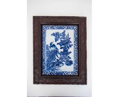 A Chinese porcelain blue &amp; white plaque, 19th century, painted with a bird upon a rocky outcrop eyeing an insect alightin