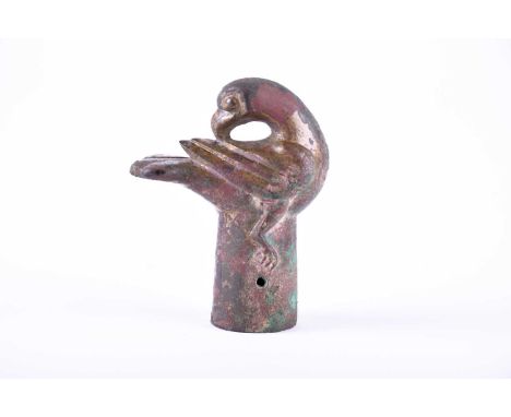 A Chinese bronze staff finial in the form of a preening hawk, Warring States or Western Han Dynasty, its head turned to atten