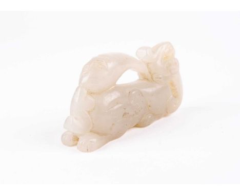 A Chinese jade carving of a mythical beast, 20th century, the recumbent beast with scrolls on its haunches and a phoenix on i