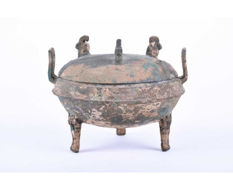 Warring States Period, 475-221 BC. A squat bronze Ding vessel with three mask legs, median ridge, with two rectangular loop h