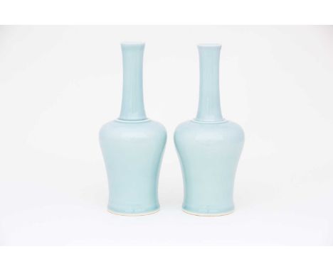 A pair of Chinese celadon mallet shape vases, each with a slightly flared rim on a slender neck terminating to a raised ring 