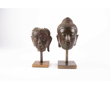 Two bronze busts of Buddha, 18th/19th century,佛首铜像两尊，18/19世纪on square metal bases, 12cm 15cm