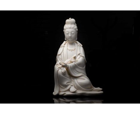 A Chinese blanc de Chine figure of Guanyin, 20th century, modelled seated, gazing serenely slightly downwards, a rui sceptre 