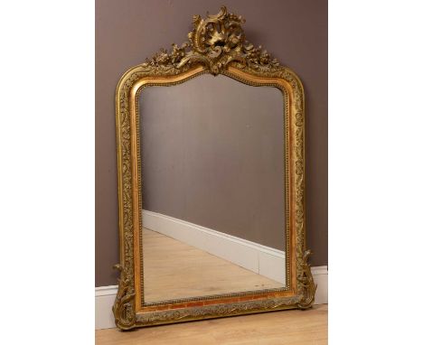 A French Rococo style wall mirror with a shaped top, the frame with scrollwork surmounted by an acanthus leaf and floral spra