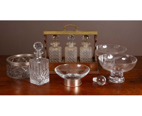 An oak tantalus with a brass carry handle and three cut glass decanters within; together with a further cut glass decanter; t