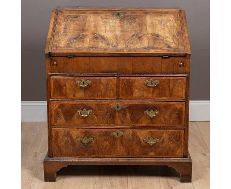 The fall front enclosing drawers and pigeon holes around a central well. The fall front backed by a leather inset writing sur
