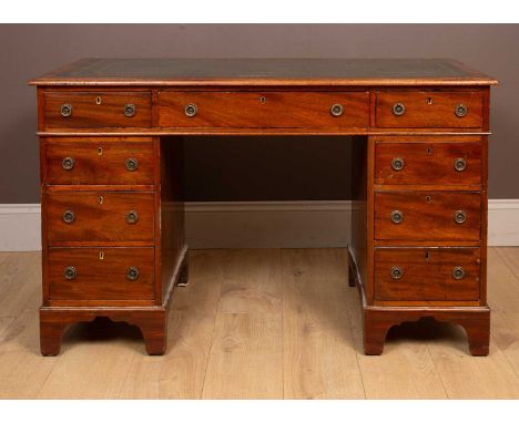 The green leather inset top with gilt tooling, above an arrangement of nine fitted drawers with ring handles, all raised on b