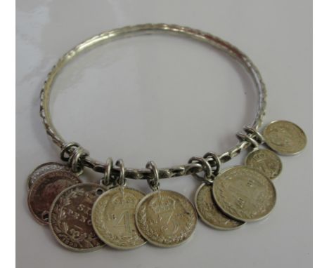 A silver bangle with Maundy coins attached