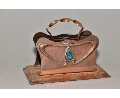 AN ARTS AND CRAFTS OAK AND COPPER LETTER RACK, twisted central handle, back and front inset with an arrow head shaped blue/gr