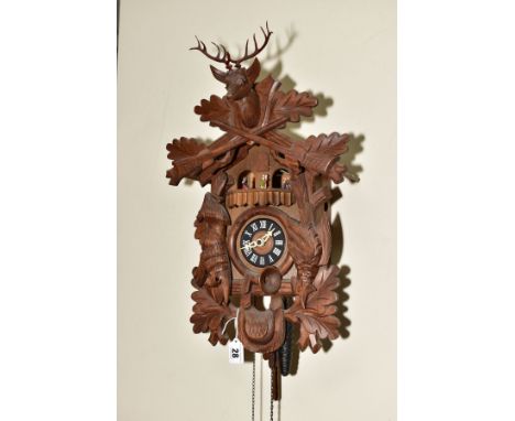 A SECOND HALF 20TH CENTURY WOODEN CUCKOO CLOCK, the case carved with gabled roof, Stag's head, hare, horn, etc, with Swiss mu
