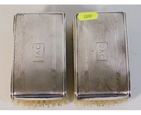A pair of silver backed clothes brushes