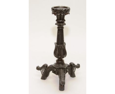 A 19th century Irish carved bog oak candlestick, raised on harp style scroll supports, 30cm high