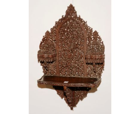 A 19th century Indian carved hardwood wall shelf, richly carved with fern and foliate decoration, with two small shelves abov