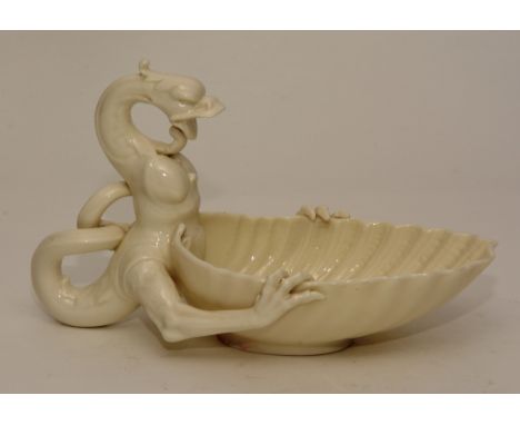 A Royal Worcester white glazed dish, in the form of a dragon holding a seashell, crown and rose stamp to base, 15cm high x 24