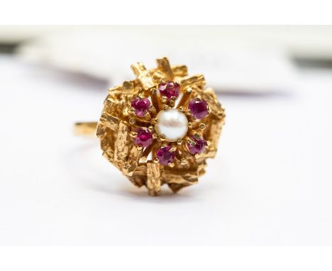 A spinel and pearl 9ct gold ring, circa 1970's, set to the centre with a cultured white pearl, with a textured gold bar surro